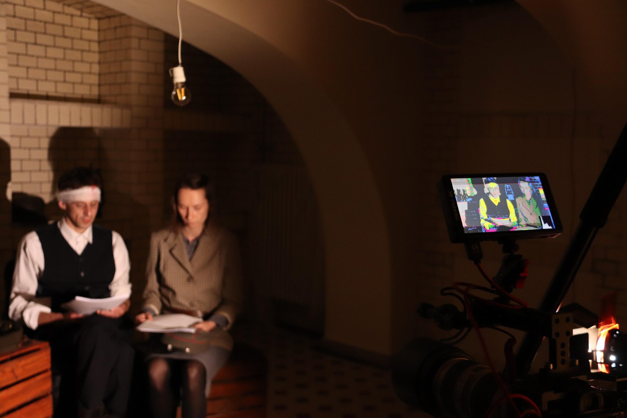 Dwoje aktorów w strojach z epoki siedzi w pomieszczeniu piwnicznym i czyta tekst sztuki. Foto Monika Bilska