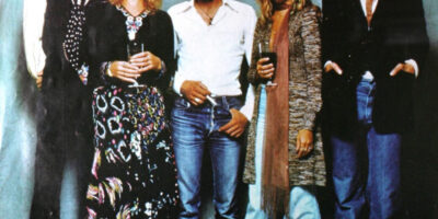 Członkowie zespołu Fleetwood Mac: 2 kobiety o włosach w kolorze blond oraz 3 mężczyźni o ciemnych włosach z brodami.