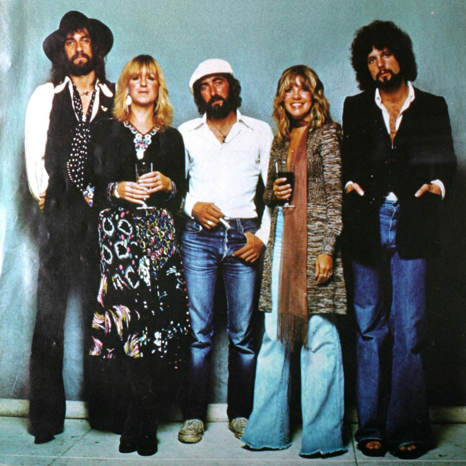 Członkowie zespołu Fleetwood Mac: 2 kobiety o włosach w kolorze blond oraz 3 mężczyźni o ciemnych włosach z brodami.