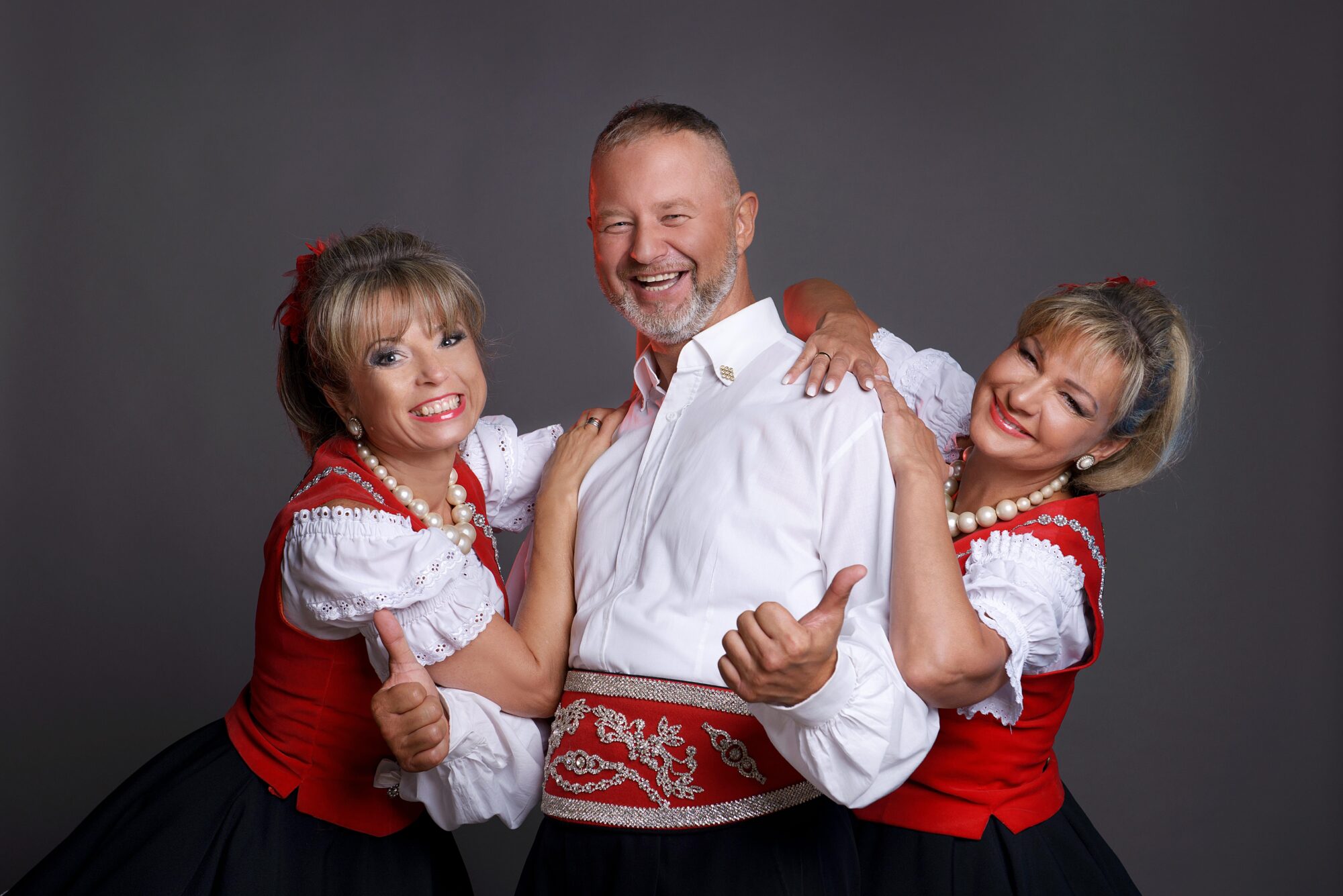 Na zdjęciu Mirek Jędrowski i jego dwie tancerki. Wszyscy ubrani w ludowe stroje.