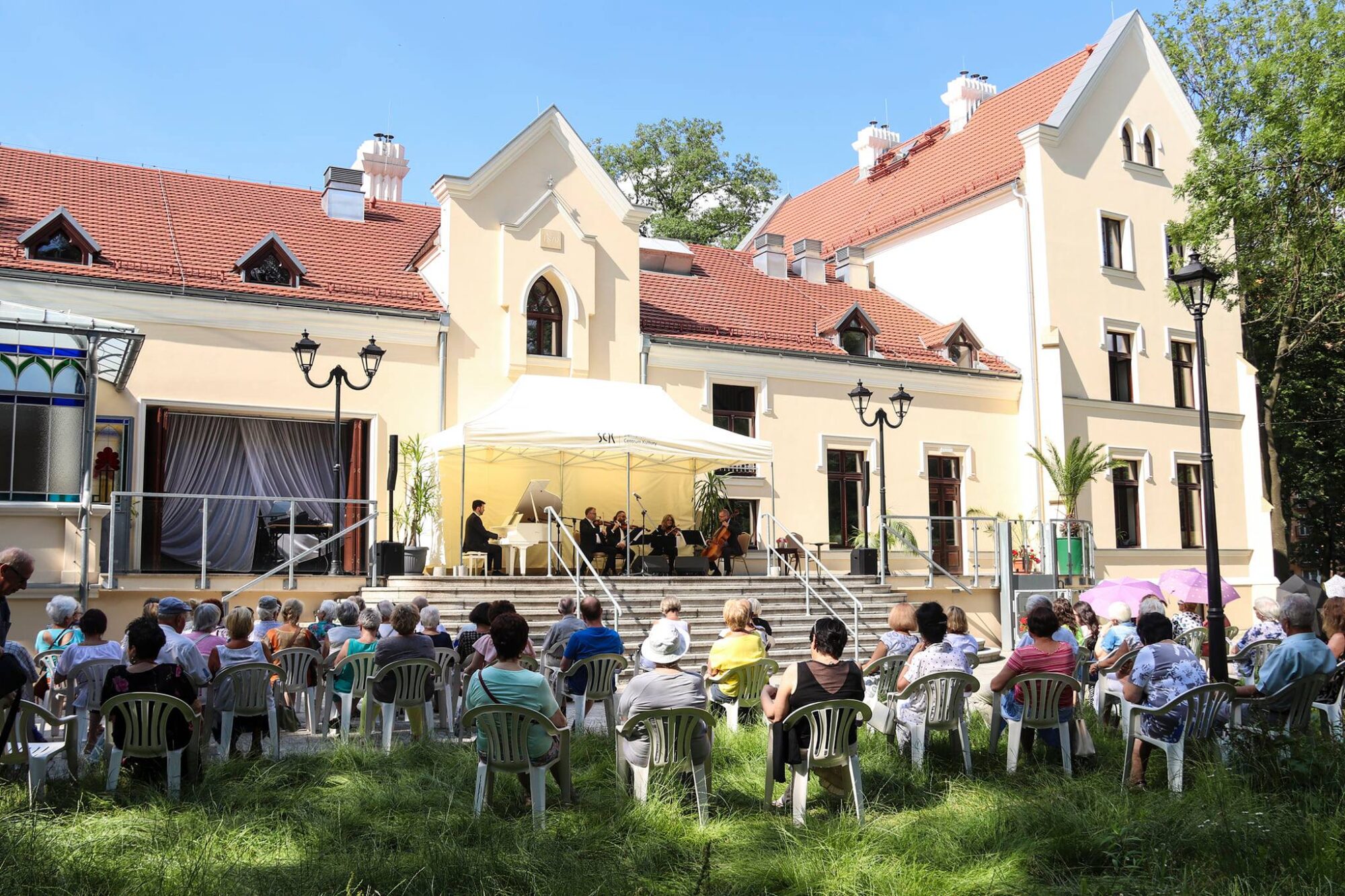 Widok z tyłu na ludzi siedzących podczas koncertu na tarasie SCK Zameczek