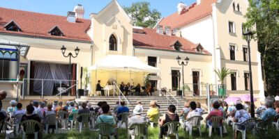 Widok z tyłu na ludzi siedzących podczas koncertu na tarasie SCK Zameczek