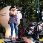 Na zdjęciu Alicja Boncol podczas koncertu w Siemianowicach Śląskich. Widać również motocykl będący elementem dekoracji oraz biał balon reklamowy SCK. Foto Monika Bilska