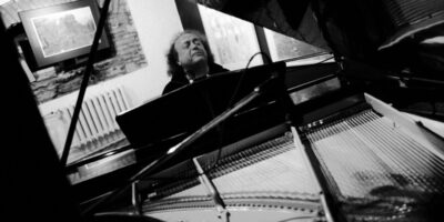 Zdjęcie przedstawia Józefa Skrzeka grającego na fortepianie