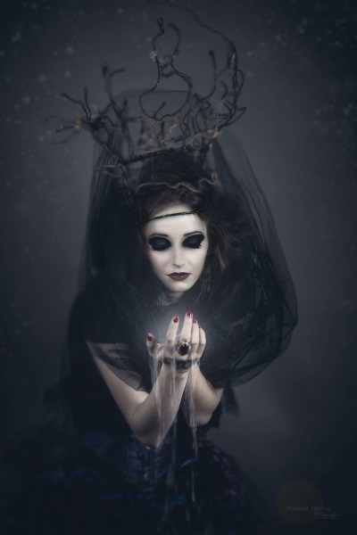 Zdjęcie przedstawia postać kobiety ucharakteryzowaną na czarownicę.