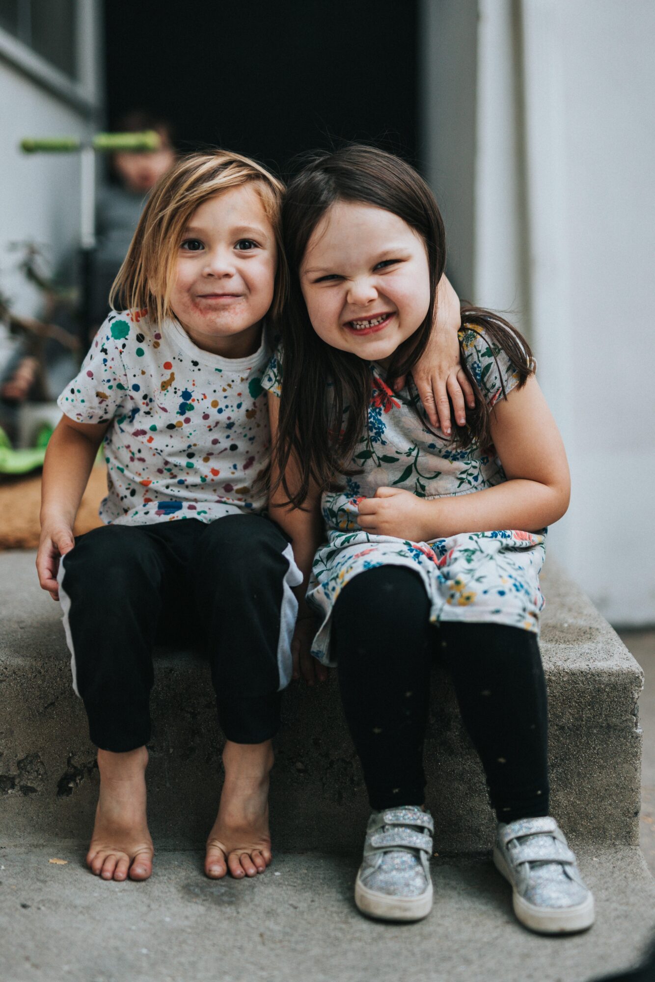 na zdjęciu dwie małe dziewczynki, objęte, uśmiechają się