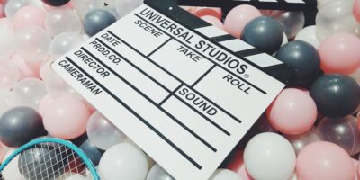 Czarno-biały klaps filmowy wśród kolorowych kulek.