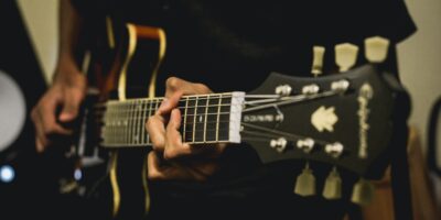 Zbliżenie na gitarę trzymaną przez gitarzystę