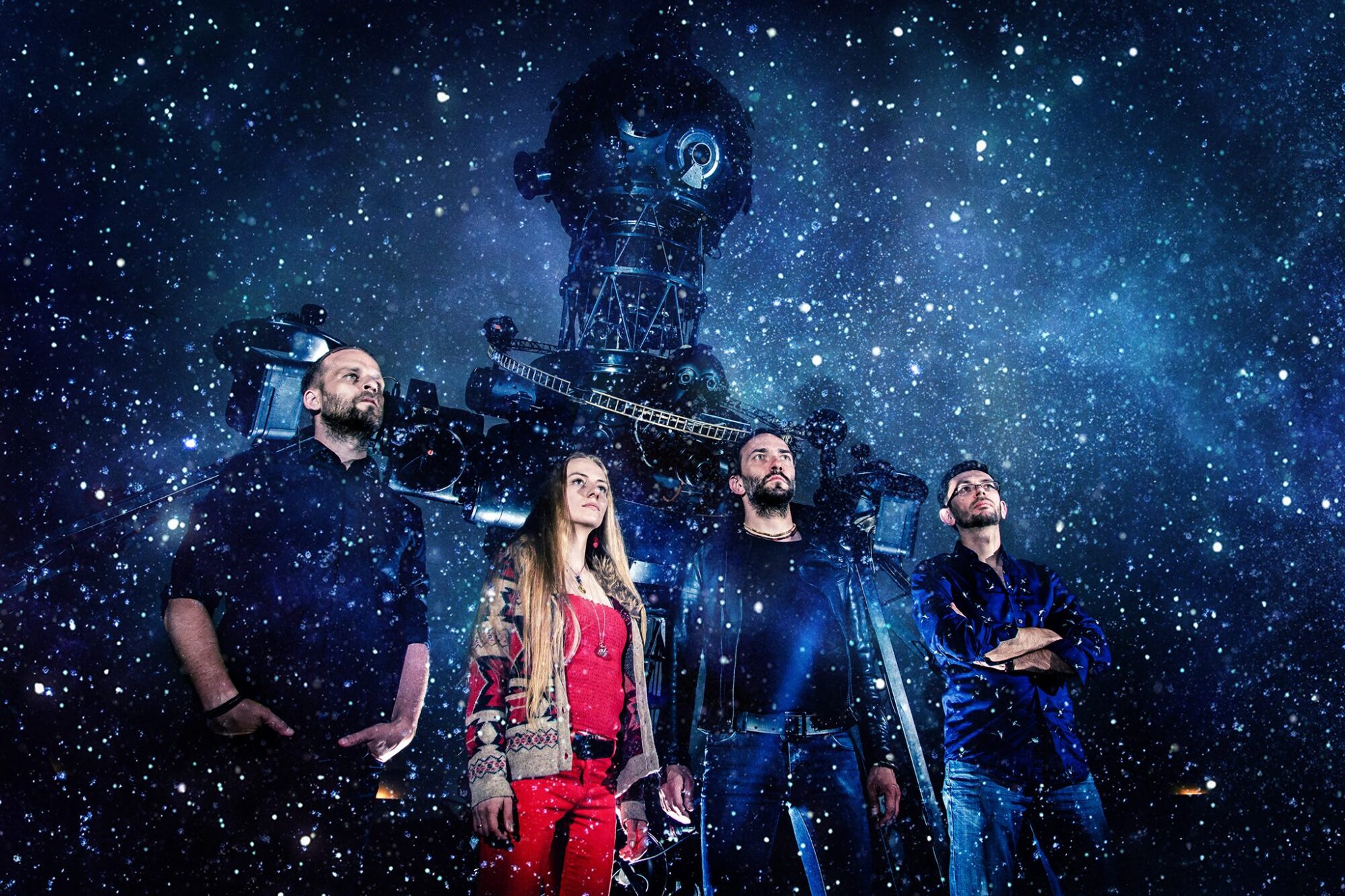 Cztery osoby stojące na tle urządzenia do wyświetlania mapy gwiazd w planetarium